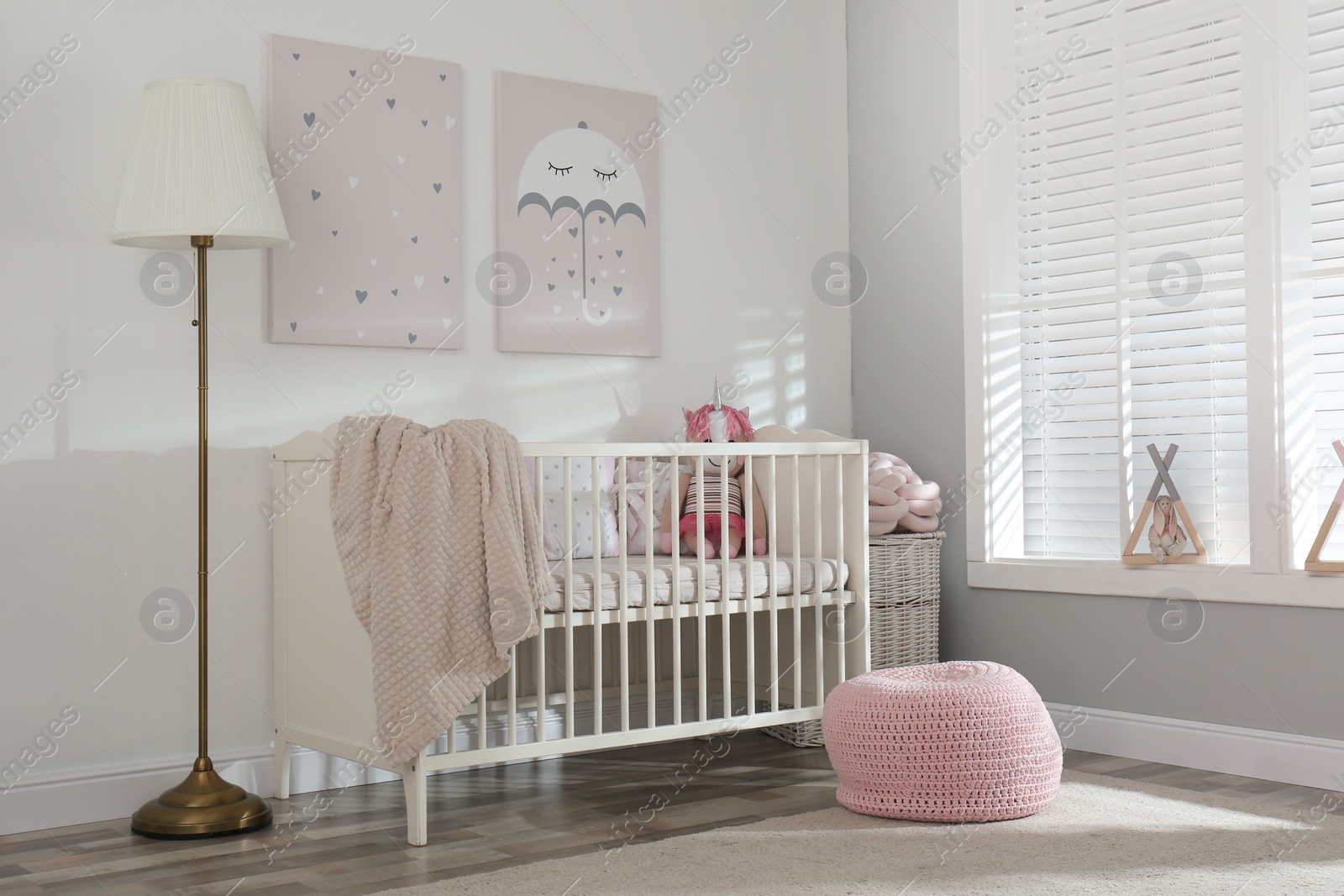 Photo of Stylish baby room interior with crib and cute pictures on wall