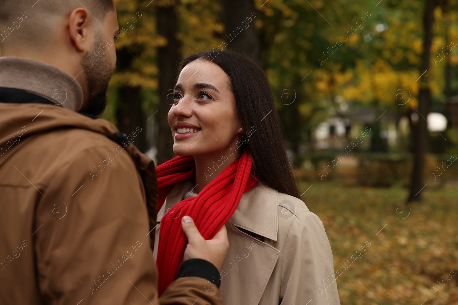 Photo of Romantic young couple spending time together in autumn park, space for text