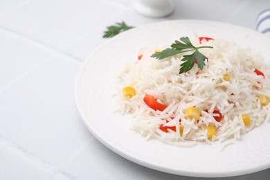 Photo of Delicious rice with vegetables and parsley on white table, closeup