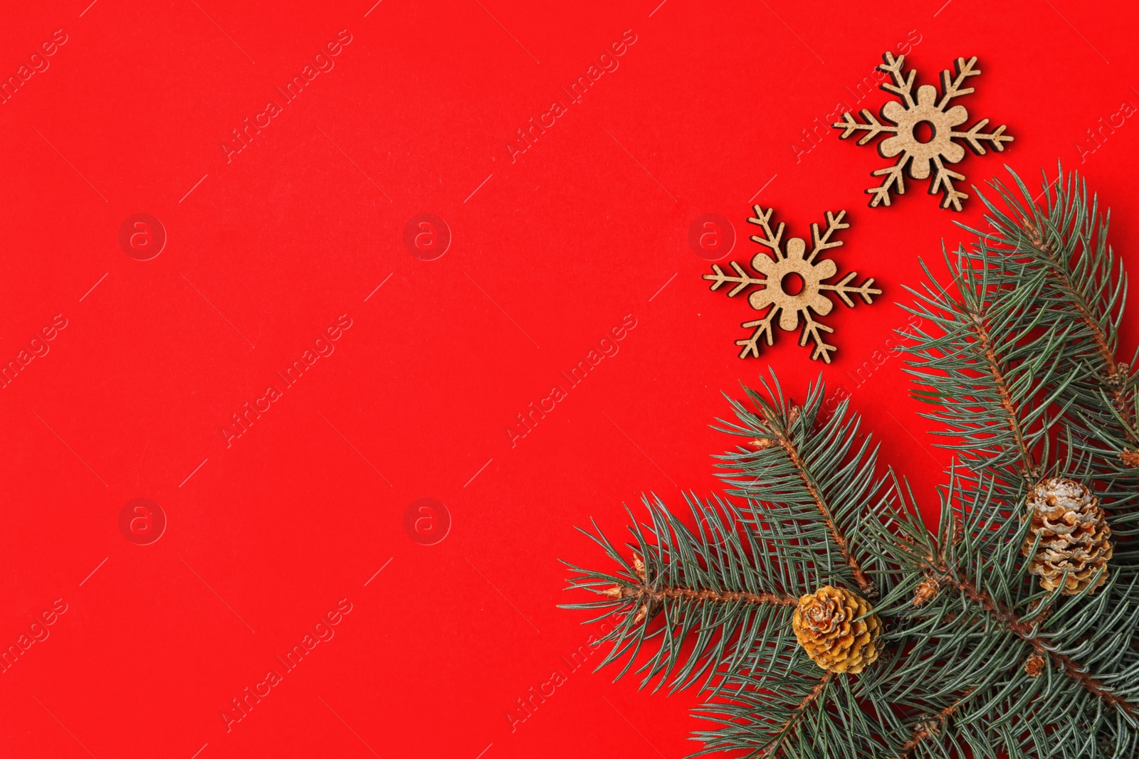 Photo of Christmas flat lay composition with fir branches on red background, space for text. Winter holidays