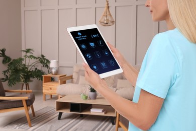 Image of Woman using smart home control system via application on tablet indoors, closeup