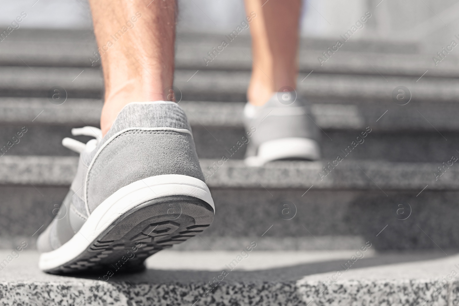 Photo of Sporty young man in training shoes outdoors, closeup