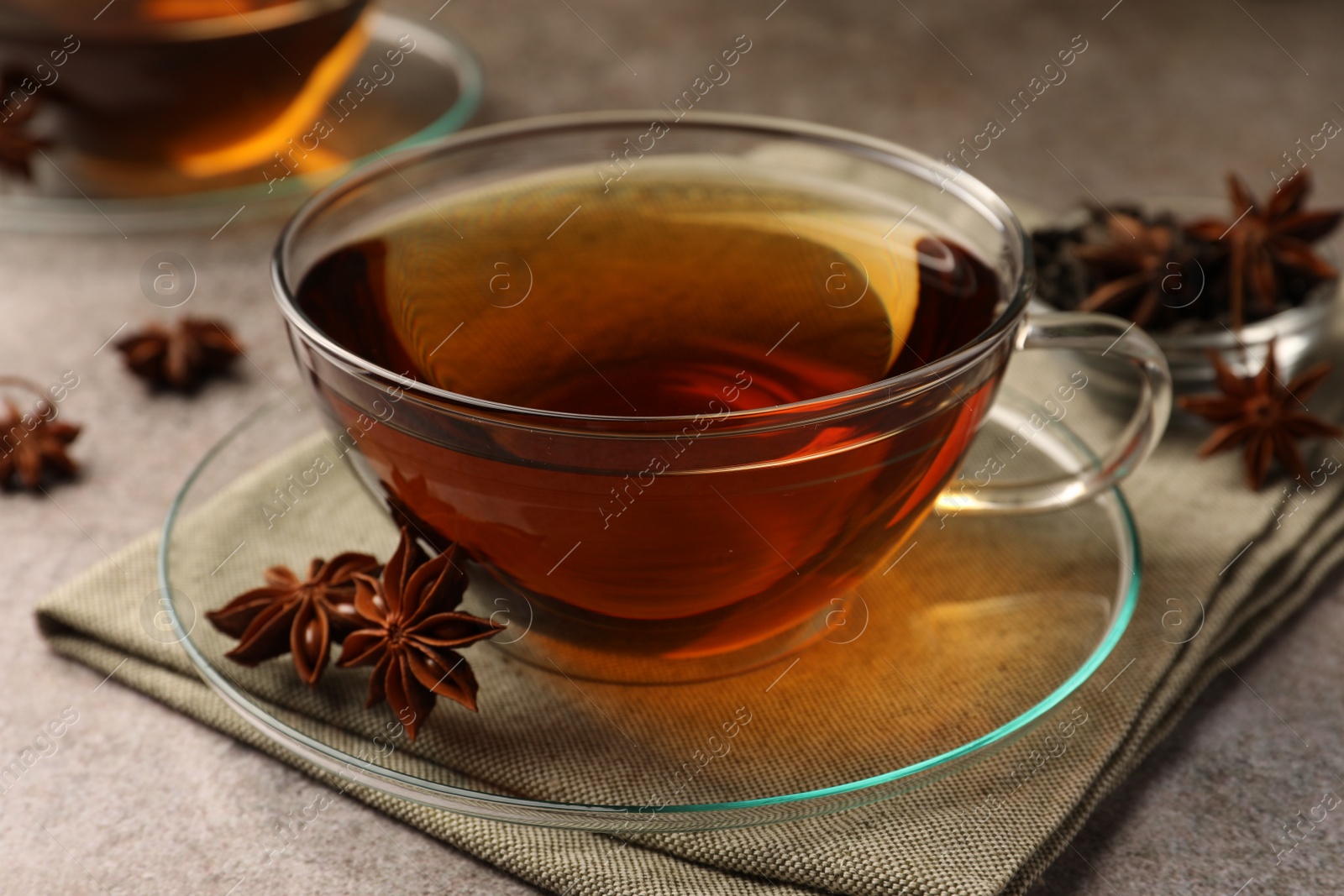 Photo of Aromatic tea with anise stars on light grey table, closeup