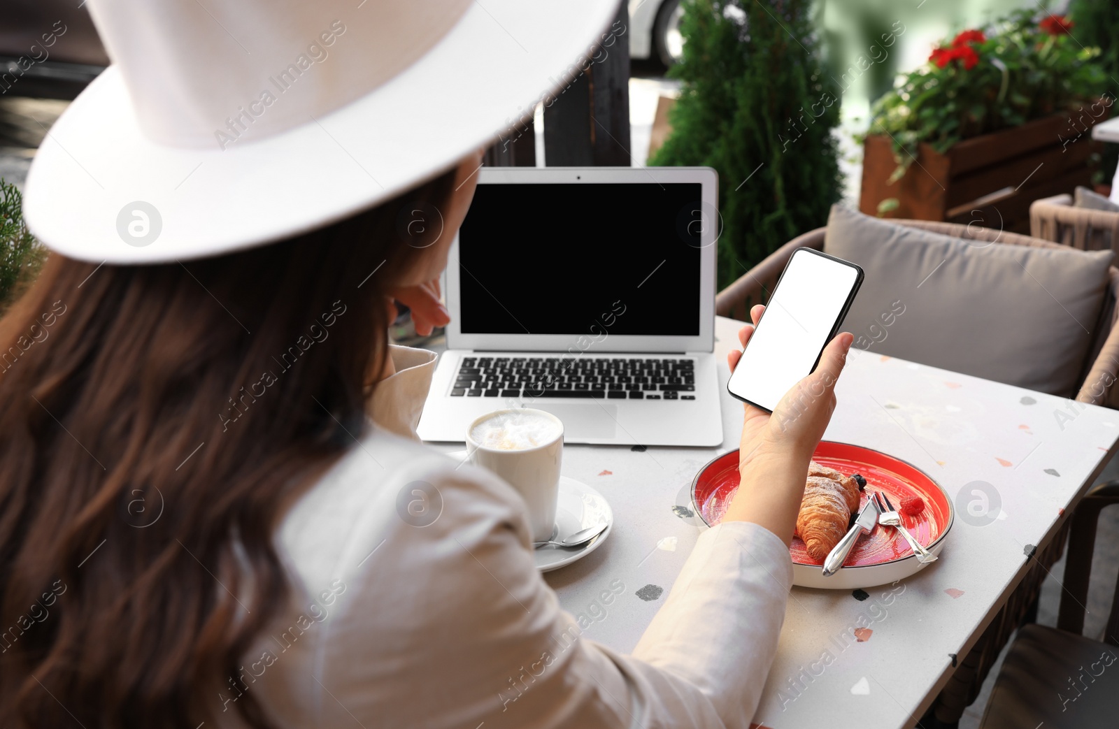 Photo of Woman using smartphone in outdoor cafe, closeup