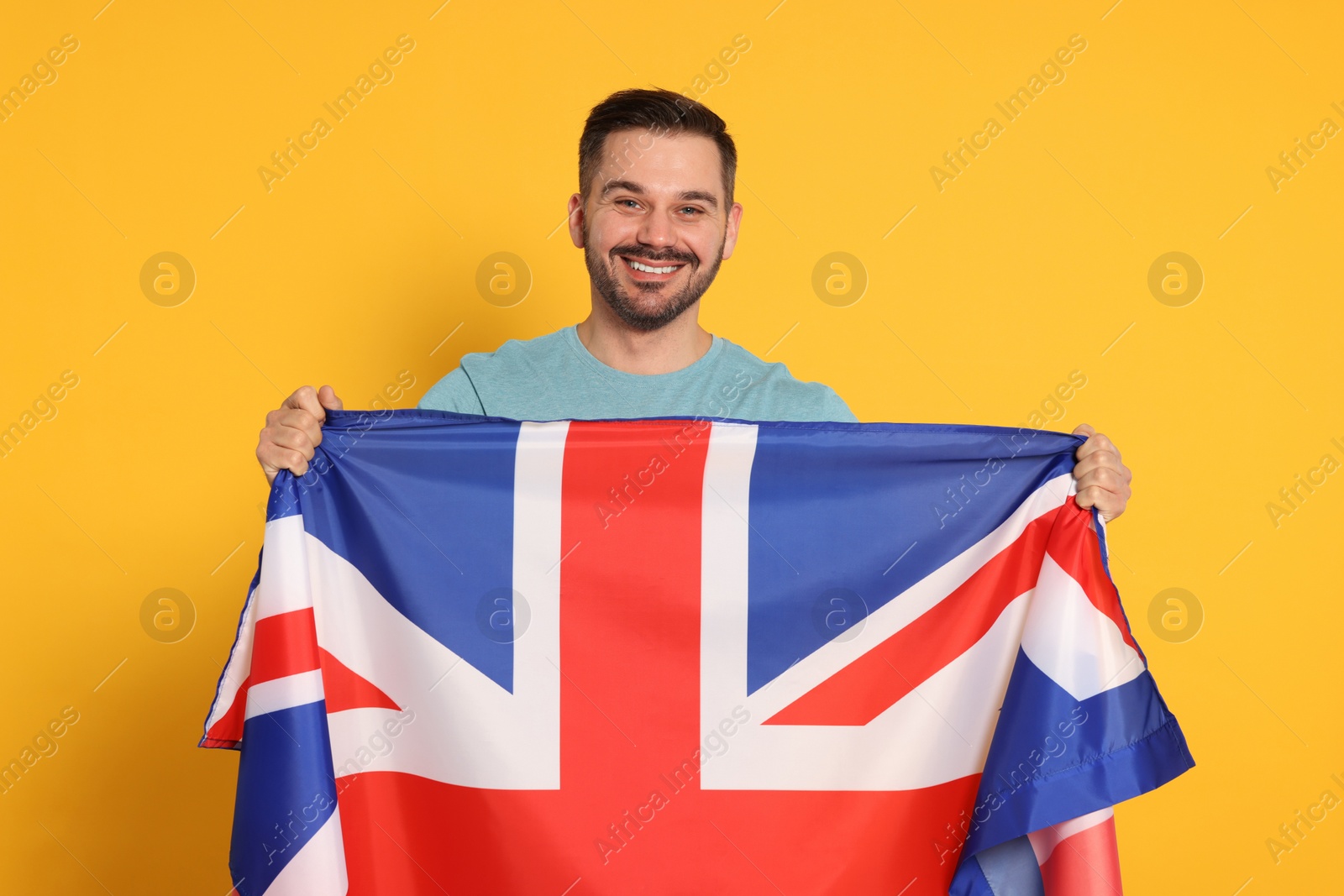 Photo of Man with flag of United Kingdom on yellow background