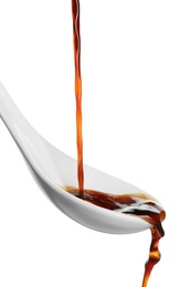 Pouring soy sauce into spoon against white background