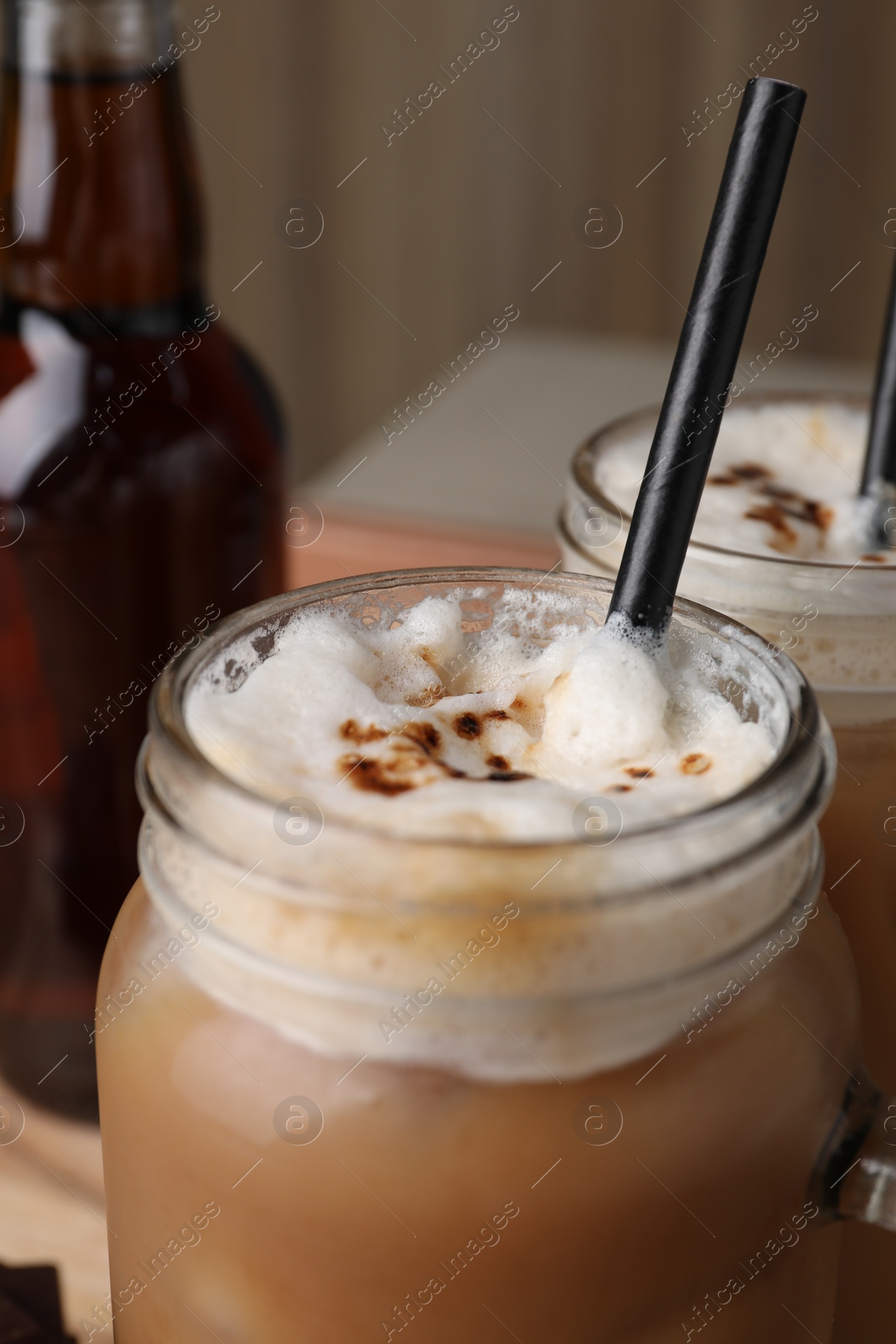 Photo of Mason jar of delicious iced coffee with chocolate syrup, closeup