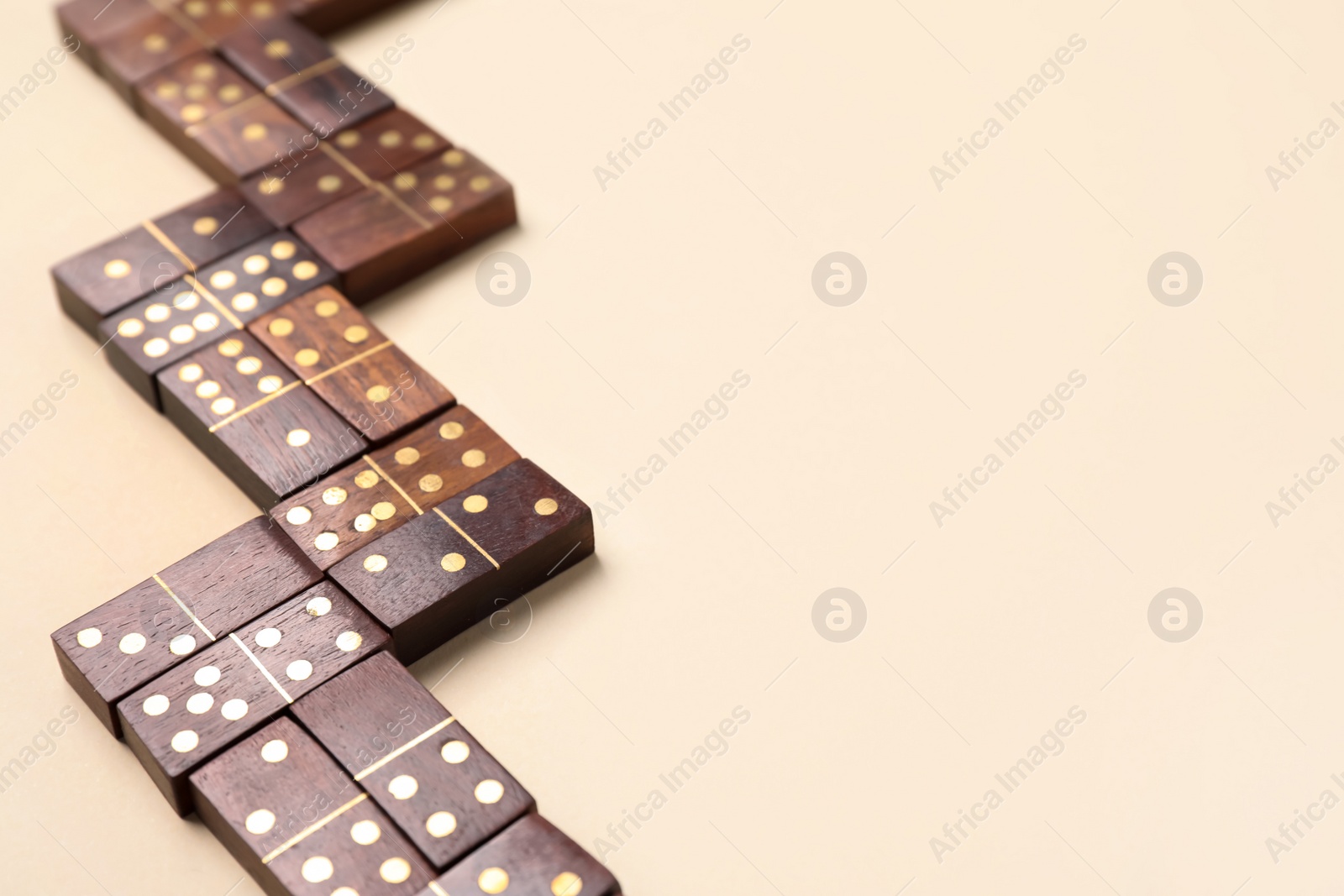 Photo of Wooden domino tiles on beige background. Space for text