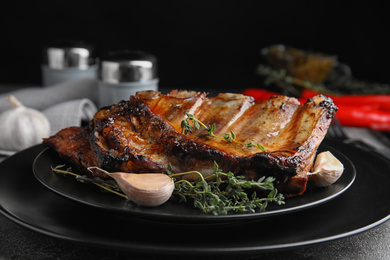 Photo of Tasty grilled ribs with thyme on grey table