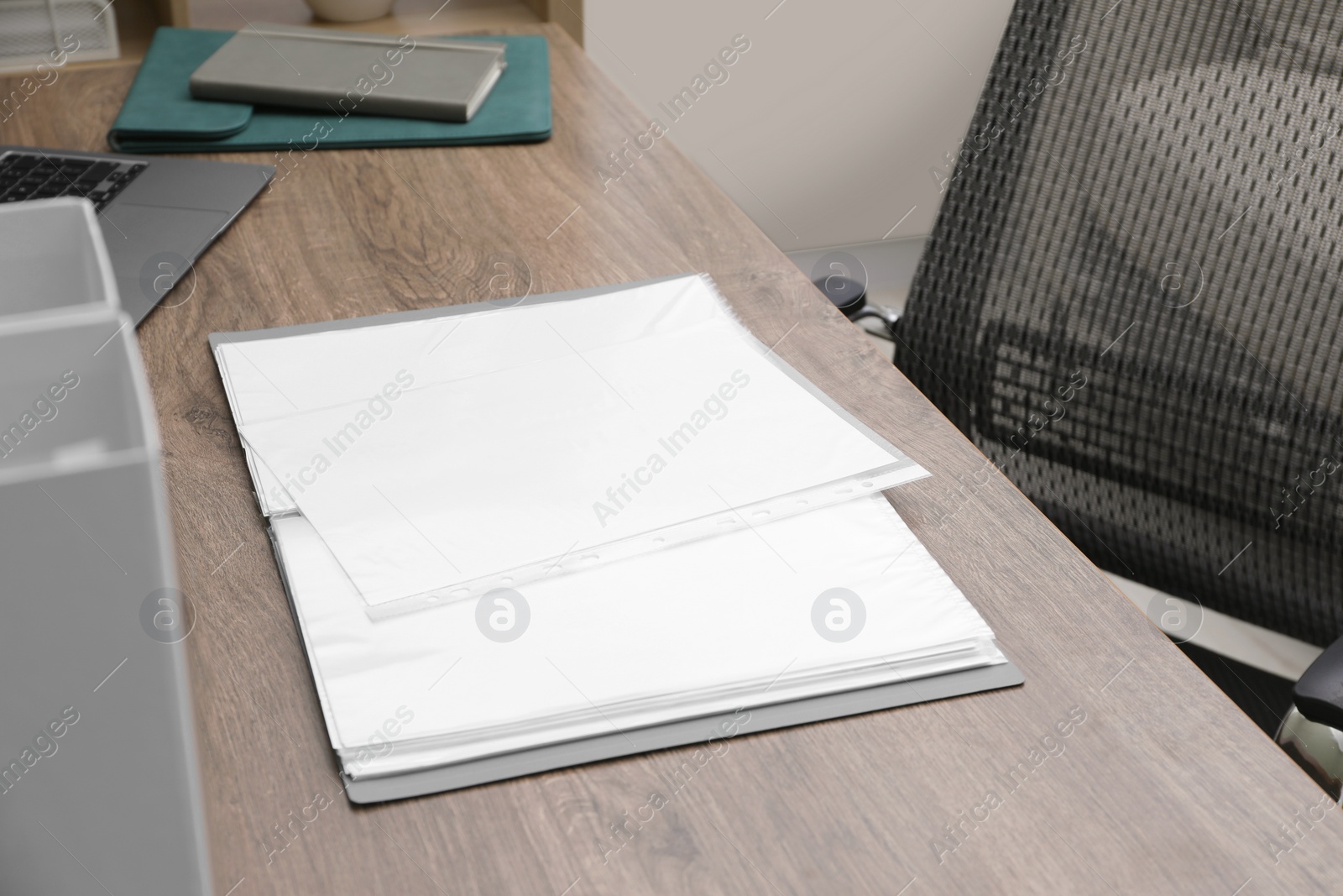 Photo of Folder with punched pockets on wooden table in office