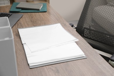 Folder with punched pockets on wooden table in office