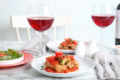 Photo of Plate with stuffed cabbage leaves in tomato sauce on table