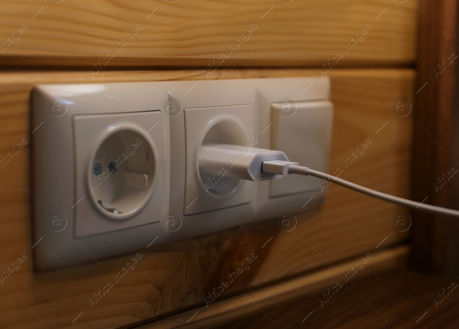 Photo of Charging plug with USB cable in socket on wall