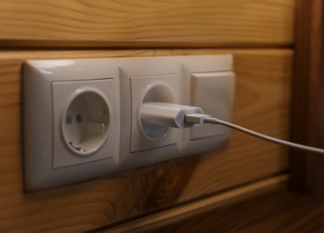 Photo of Charging plug with USB cable in socket on wall