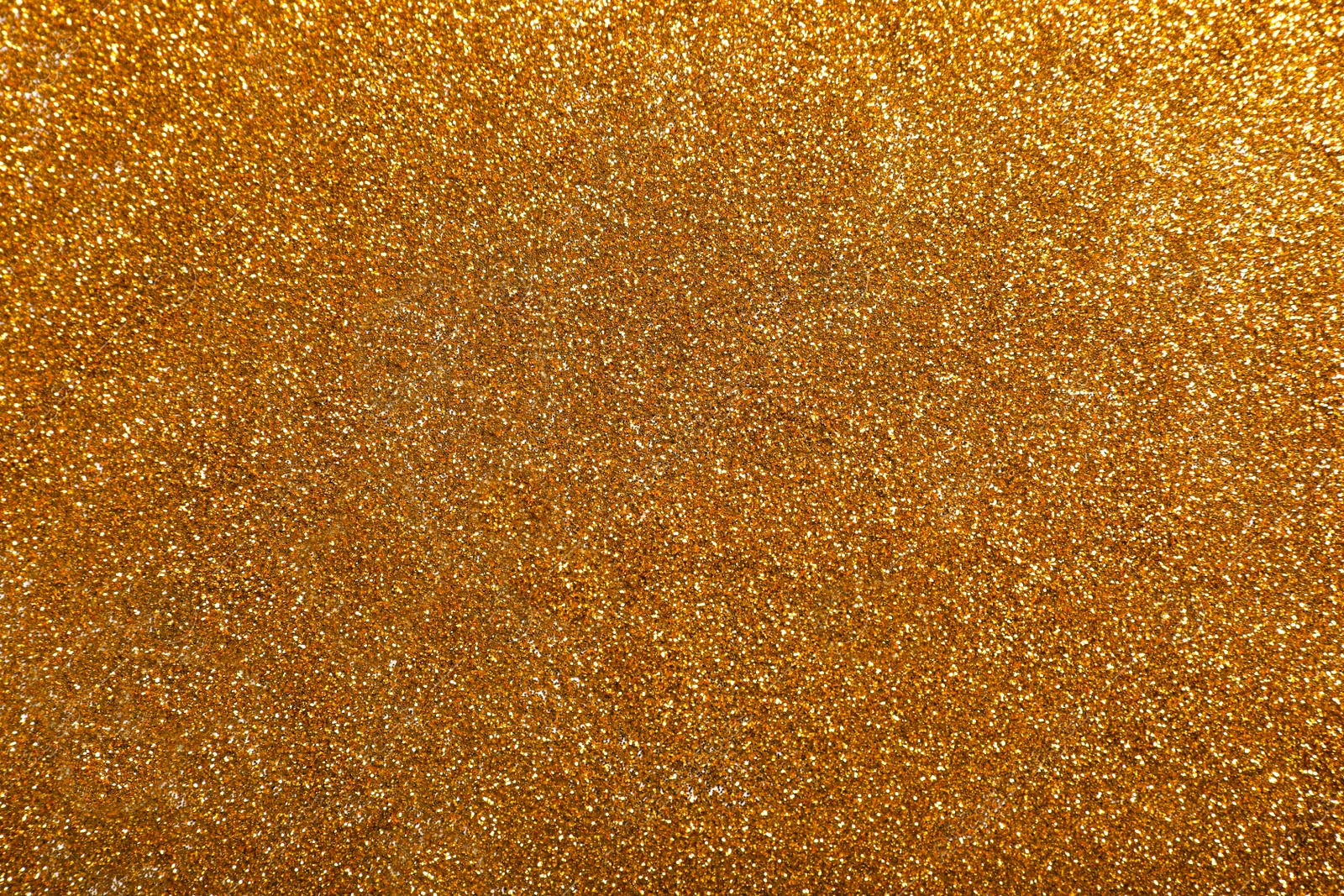 Photo of Shiny bright golden glitter as background, top view