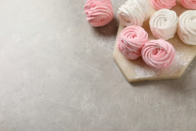 Delicious pink and white marshmallows on grey table. Space for text