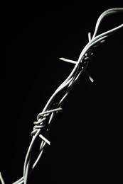 Metal barbed wire on black background, closeup