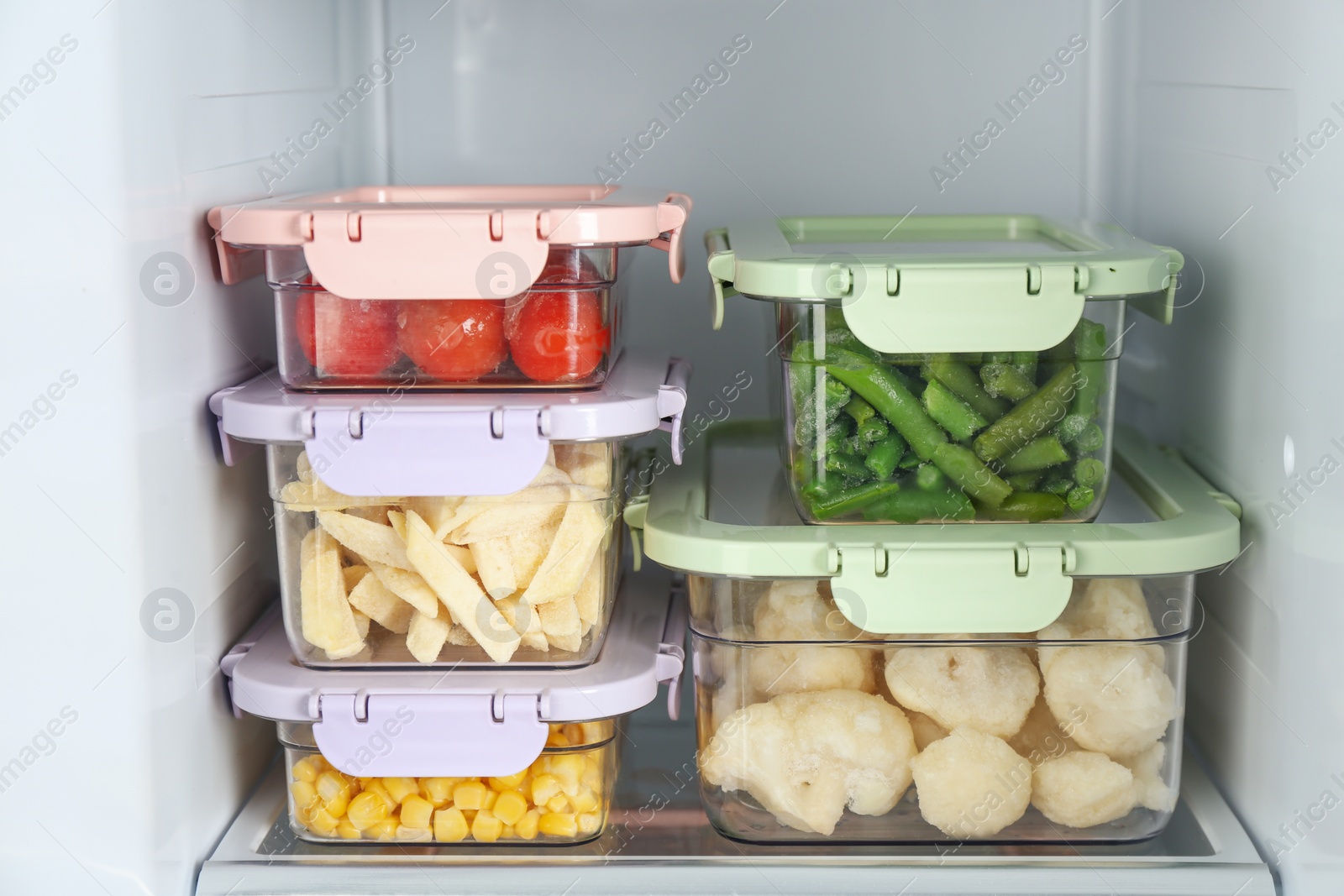 Photo of Containers with different frozen vegetables in refrigerator