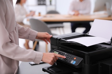 Employee using modern printer in office, closeup