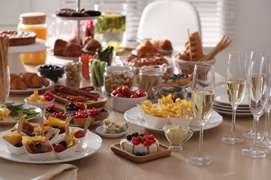 Photo of Variety of snacks on wooden table in buffet style indoors