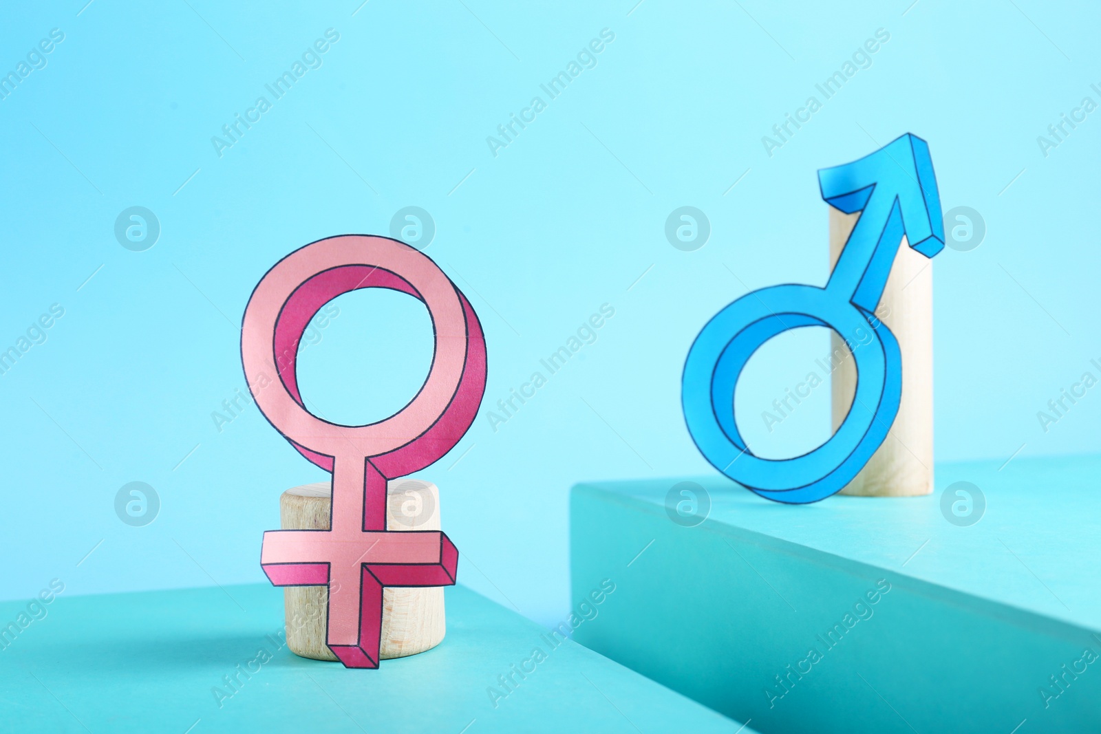 Photo of Gender pay gap. Male and female symbols on light blue background