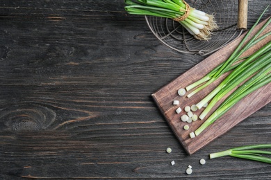 Photo of Beautiful composition with fresh green onion on wooden table, top view