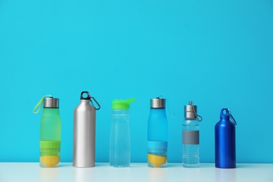 Different water bottles for sports on color background. Space for text