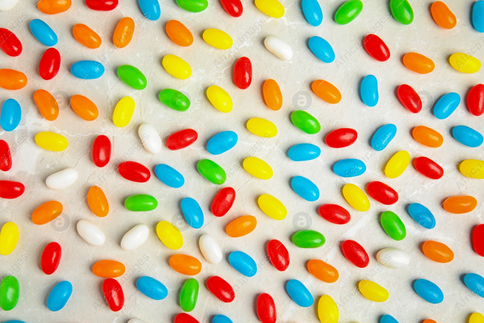 Photo of Flat lay composition with jelly beans on light background
