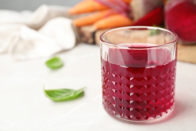 Glass with fresh beet juice on table