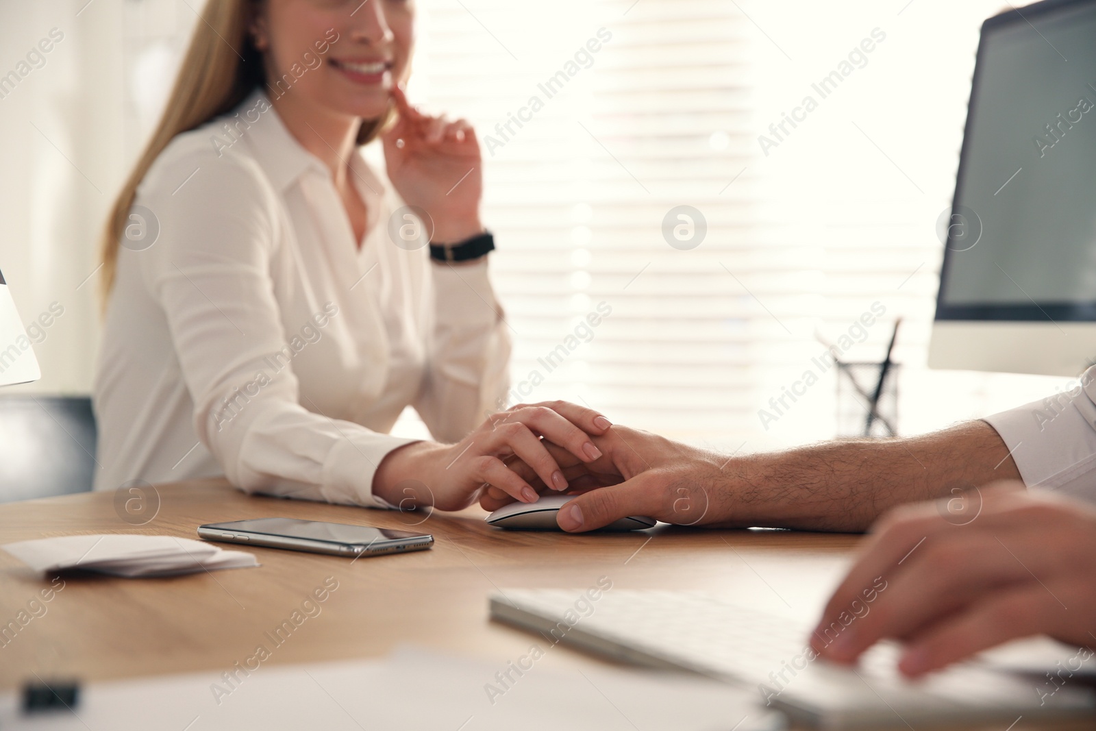 Photo of Young woman flirting with her colleague during work in office, closeup