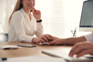 Young woman flirting with her colleague during work in office, closeup