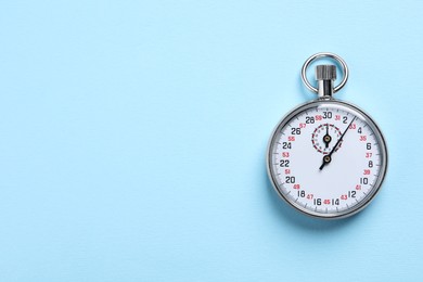 Photo of Vintage timer on light blue background, top view with space for text. Measuring tool