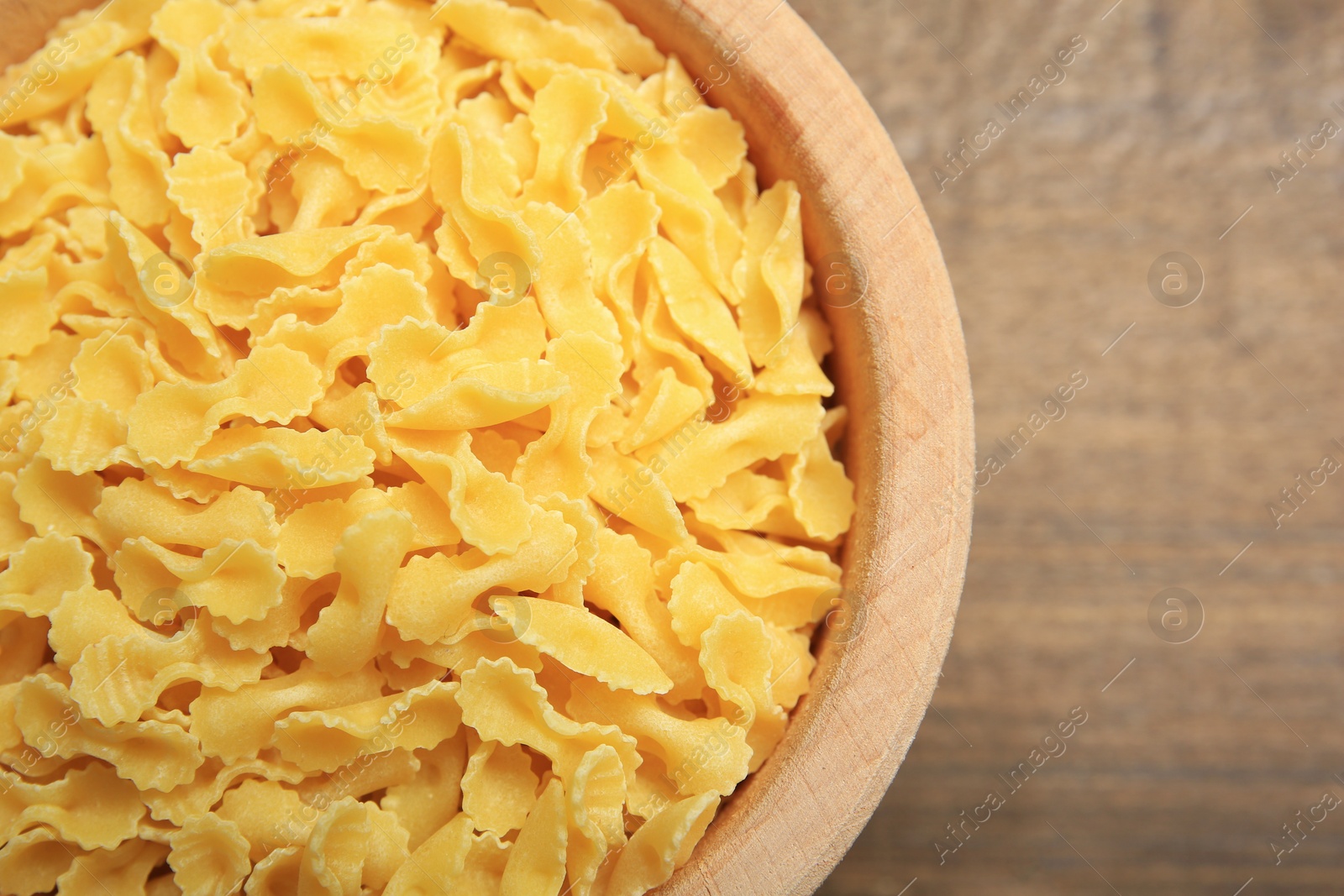 Photo of Raw farfalline pasta in bowl on table, top view