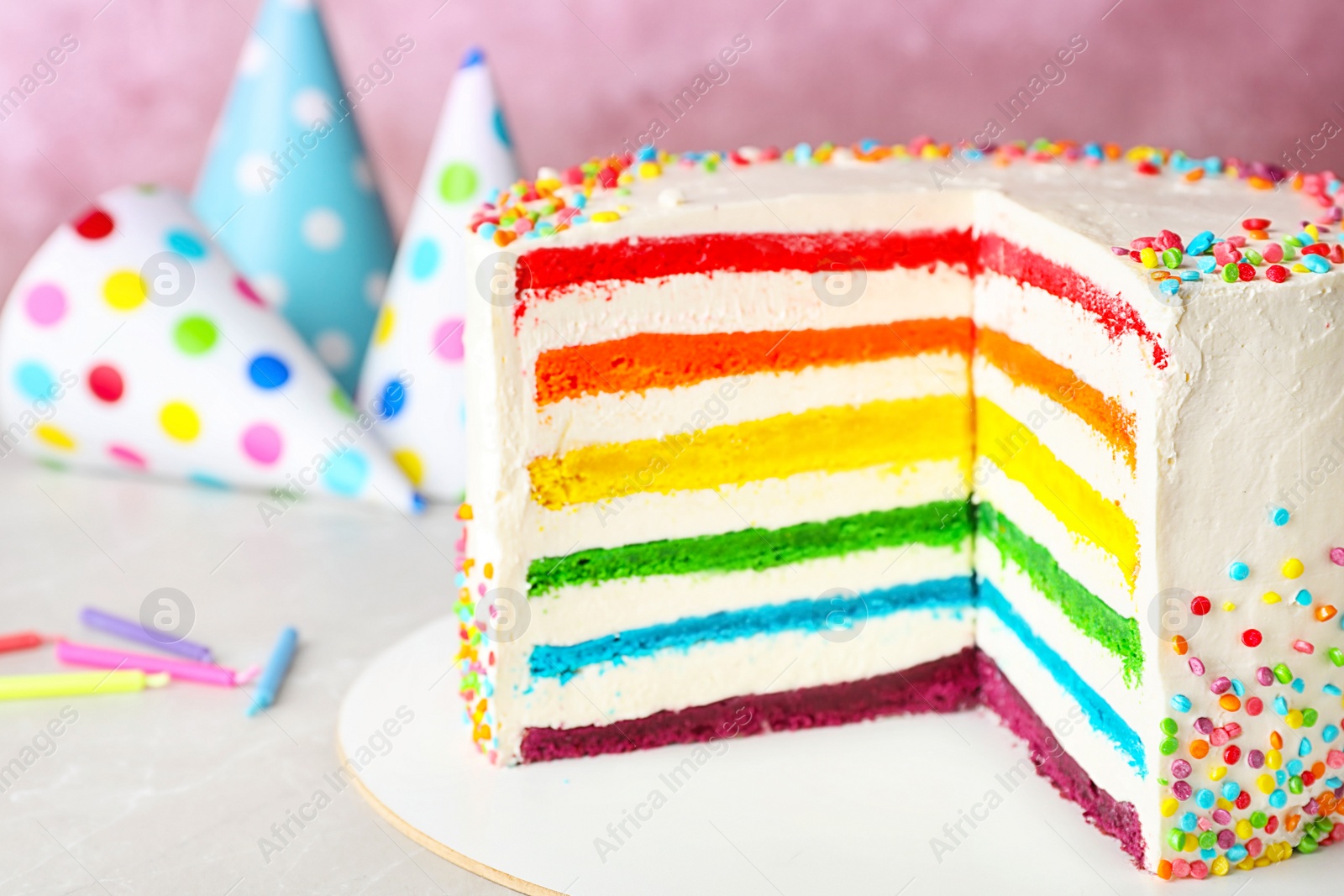 Photo of Delicious rainbow cake for party on table