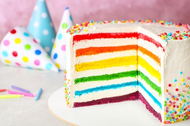 Photo of Delicious rainbow cake for party on table