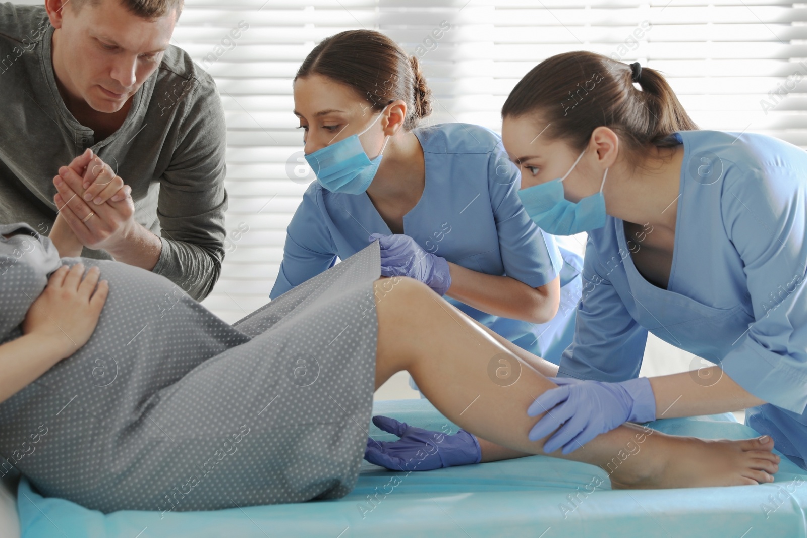 Photo of Woman giving child birth in maternity hospital, closeup