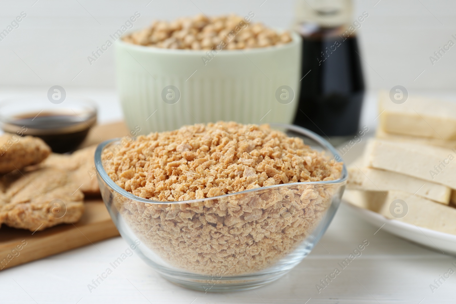 Photo of Dried soy meat and other products on white wooden table, closeup