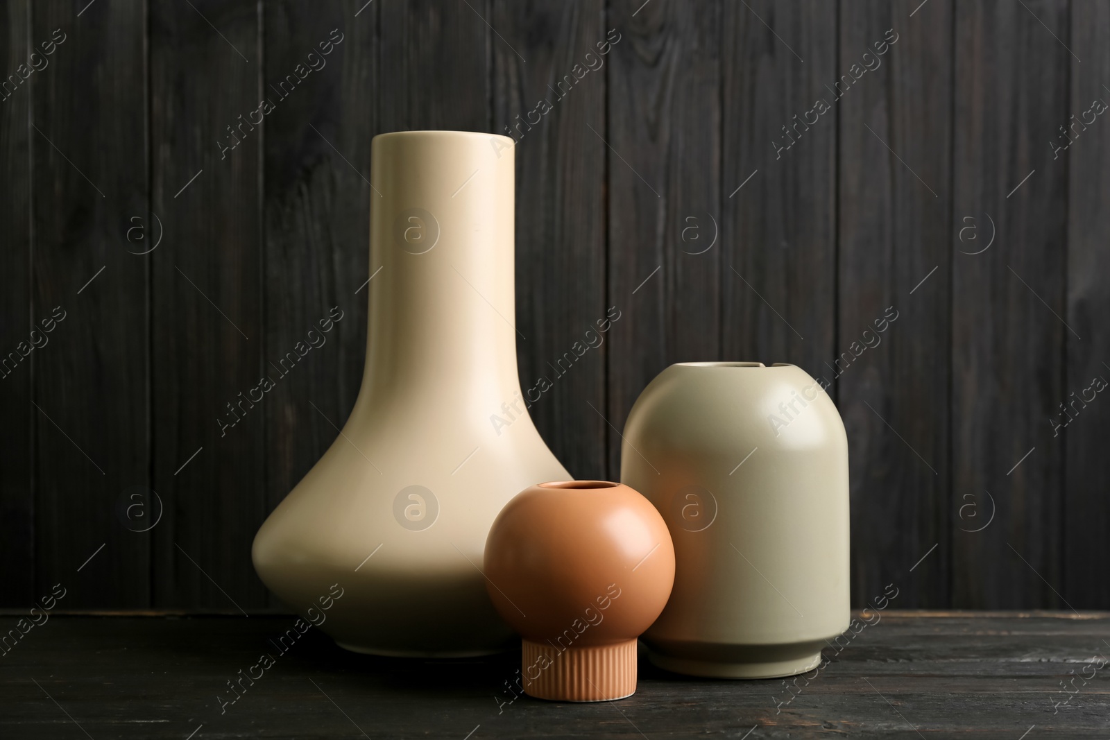 Photo of Stylish ceramic vases on black wooden table