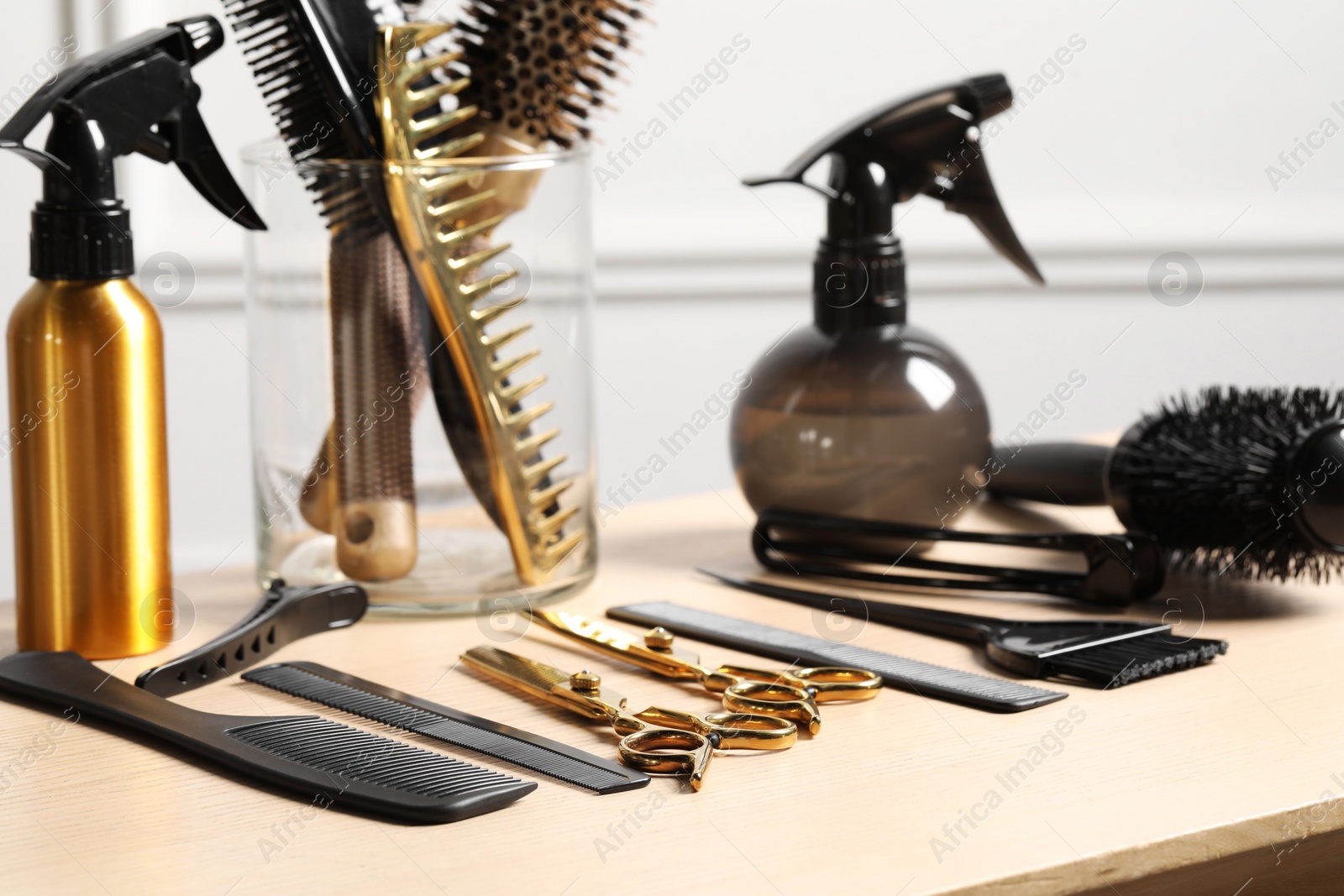 Photo of Hairdresser tools. Different scissors and combs on wooden table in salon