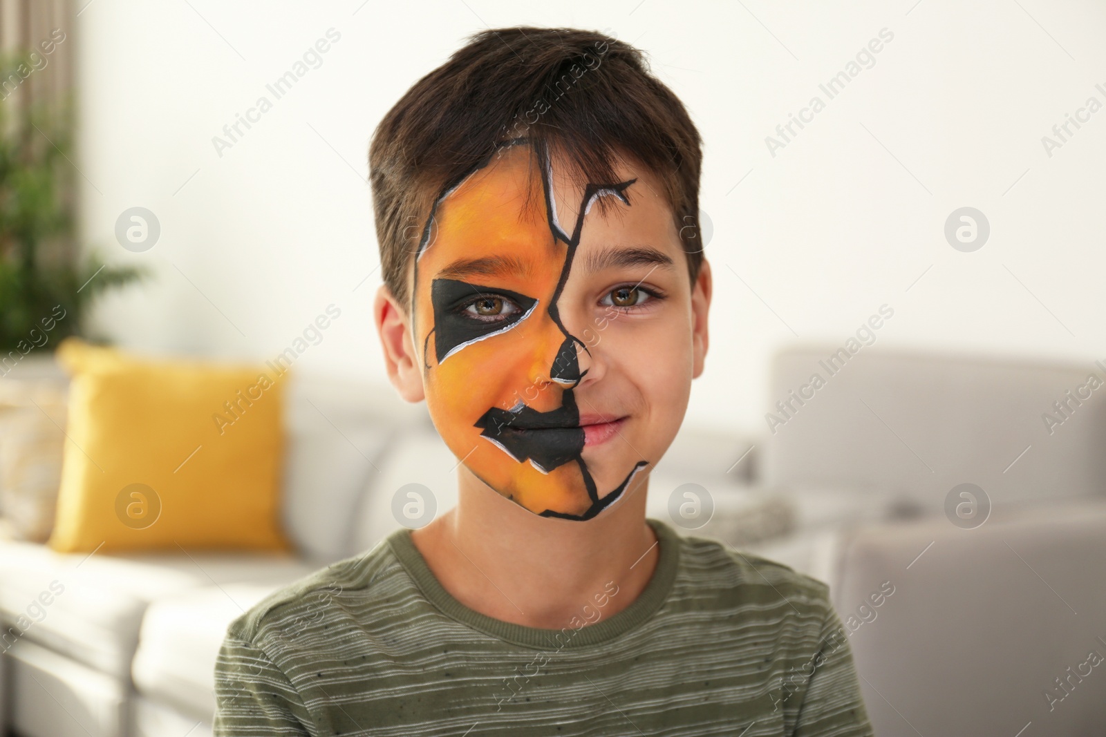 Photo of Cute little boy with face painting indoors