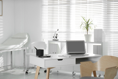 Photo of Doctor's workplace with laptop in modern clinic