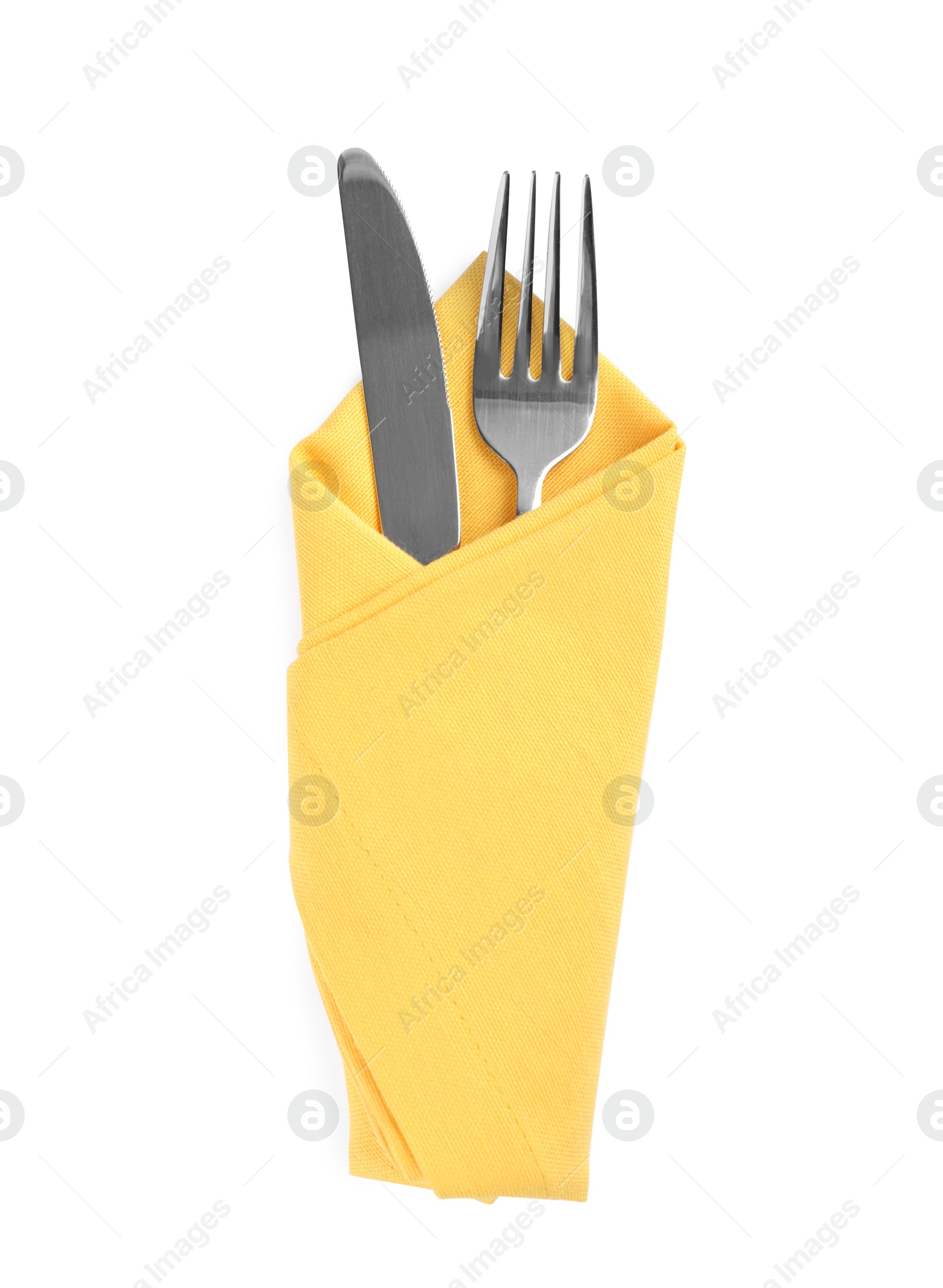 Photo of Fork and knife wrapped in yellow napkin on white background, top view