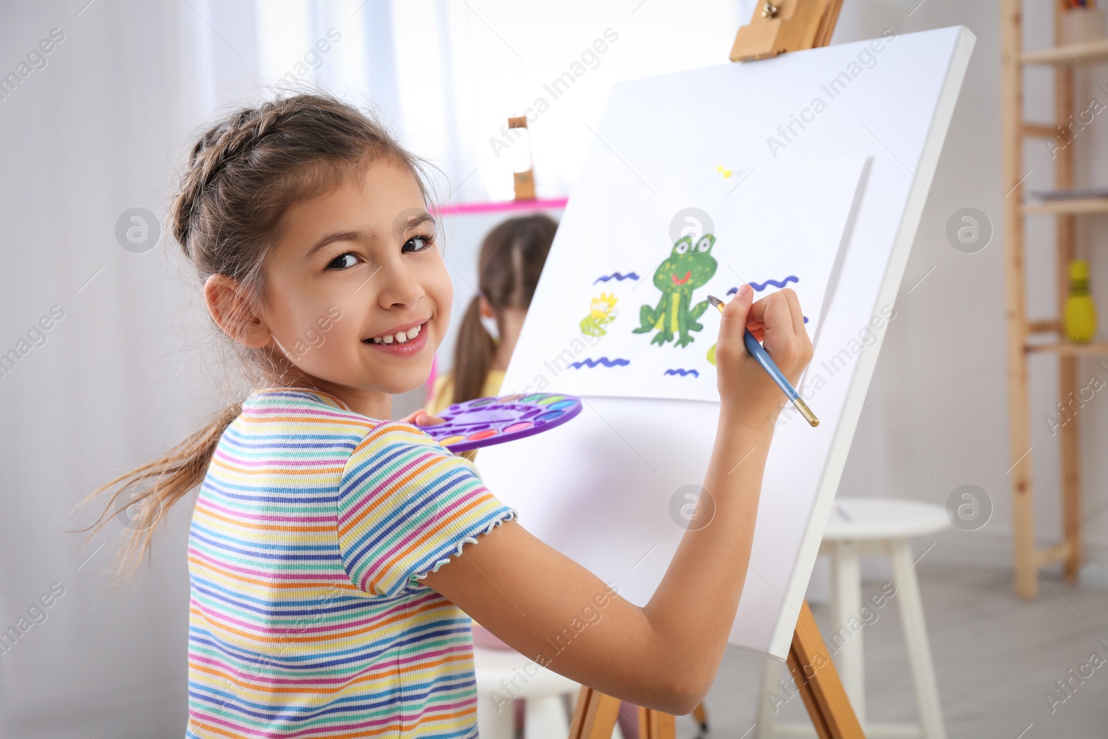 Photo of Cute little child painting during lesson in room