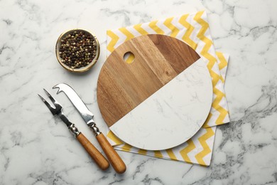 Photo of Serving board, cutlery and spices on white marble table, flat lay. Space for text