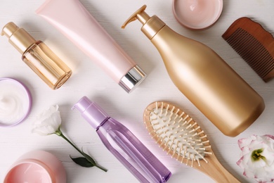 Photo of Flat lay composition with different hair products and accessories on white wooden table