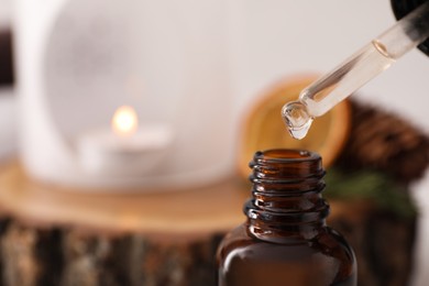 Dripping of coniferous essential oil into bottle, closeup. Space for text