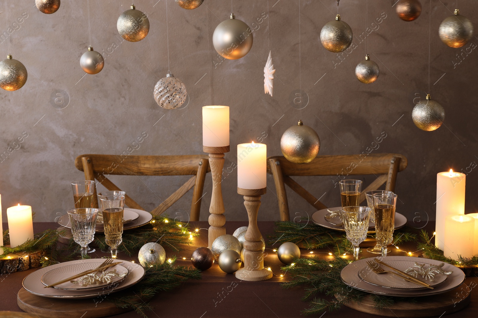 Photo of Christmas table setting with burning candles and festive decor