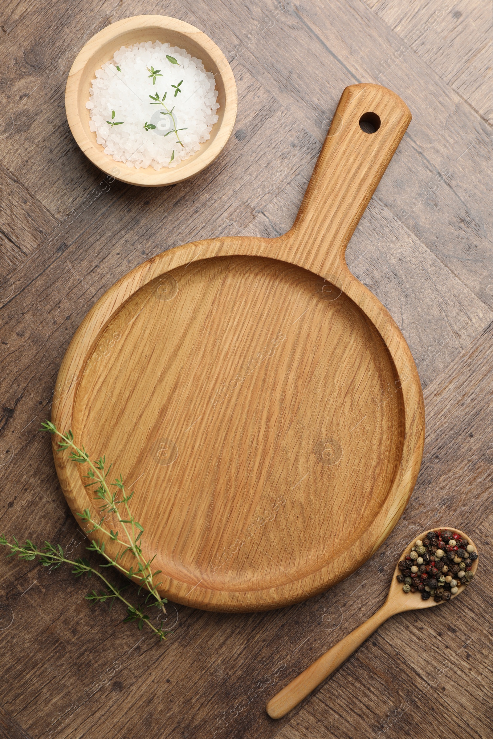 Photo of Cutting board and different spices on wooden table, flat lay