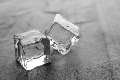 Photo of Crystal clear ice cubes with water drops on grey table, closeup