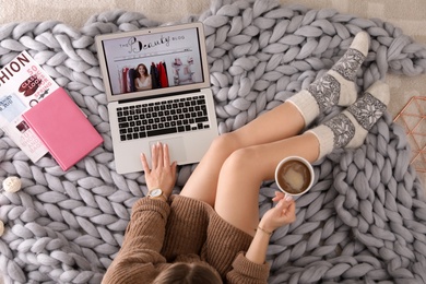 Woman and laptop with beauty blogger site on floor, top view